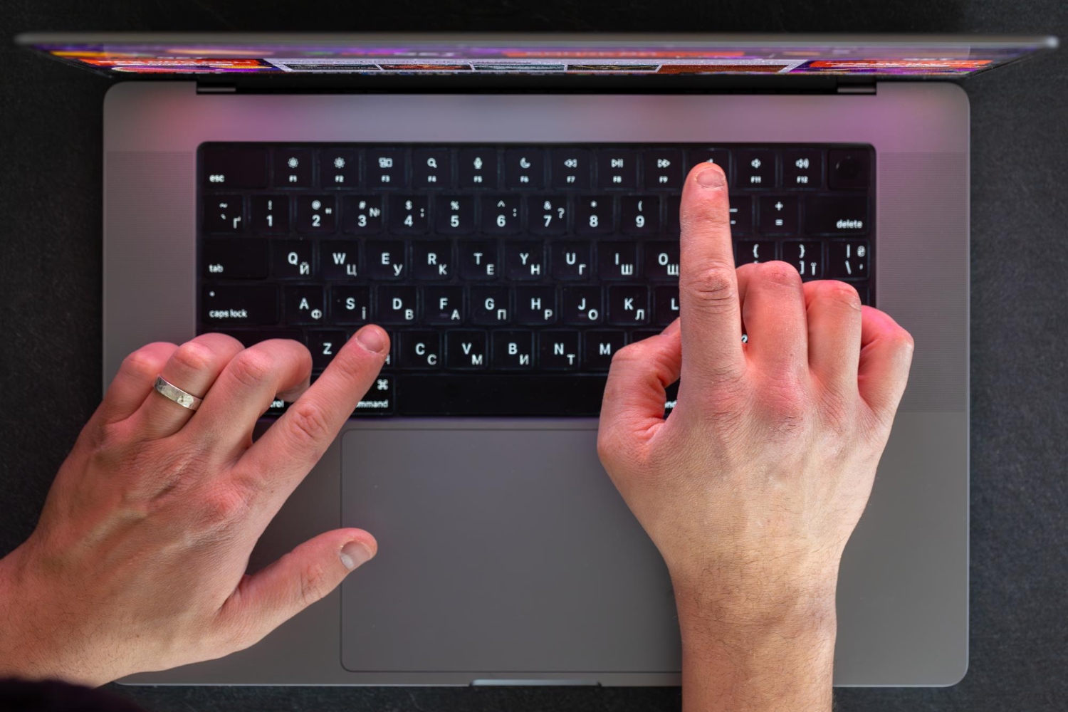 a man typing on a laptop keyboard